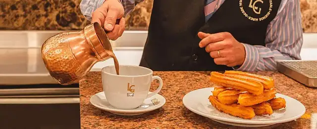 Food type: Churros beside a cup being filled with hot chocolate