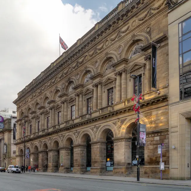 The Peter Street frontage of the Radisson Edwardian Hotel, originally built as the Free Trade Hall.
The Free Trade Hall was a public hall constructed in 1853–6 to commemorate the repeal of the Corn Laws in 1846. The hall was funded by public subscription and became a concert hall and home of the Hallé Orchestra in 1858. 
The interior of the hall had to be rebuilt after bombing during the Manchester Blitz left it an empty shell; it re-opened in 1951. As well as housing the Hallé Orchestra, it was used for pop and rock concerts; it was Manchester's premier concert venue until the construction of the Bridgewater Hall in 1996. 
When the Hallé Orchestra moved to the Bridgewater Hall in 1996, the Free Trade Hall was closed by Manchester City Council. In 1997, the building was sold to private developers and, despite much opposition because of its historical significance, planning approval was eventually granted to convert it to a hotel, retaining the original facade was, the main staircase and the 1950s statues that were formerly attached to its rear wall. The hotel opened in 2004.
The hall is designated as a Grade II* listed building.

A red plaque on the wall records that it was built on St Peter's Fields, the site of the (in)famous Peterloo Massacre in 1819.